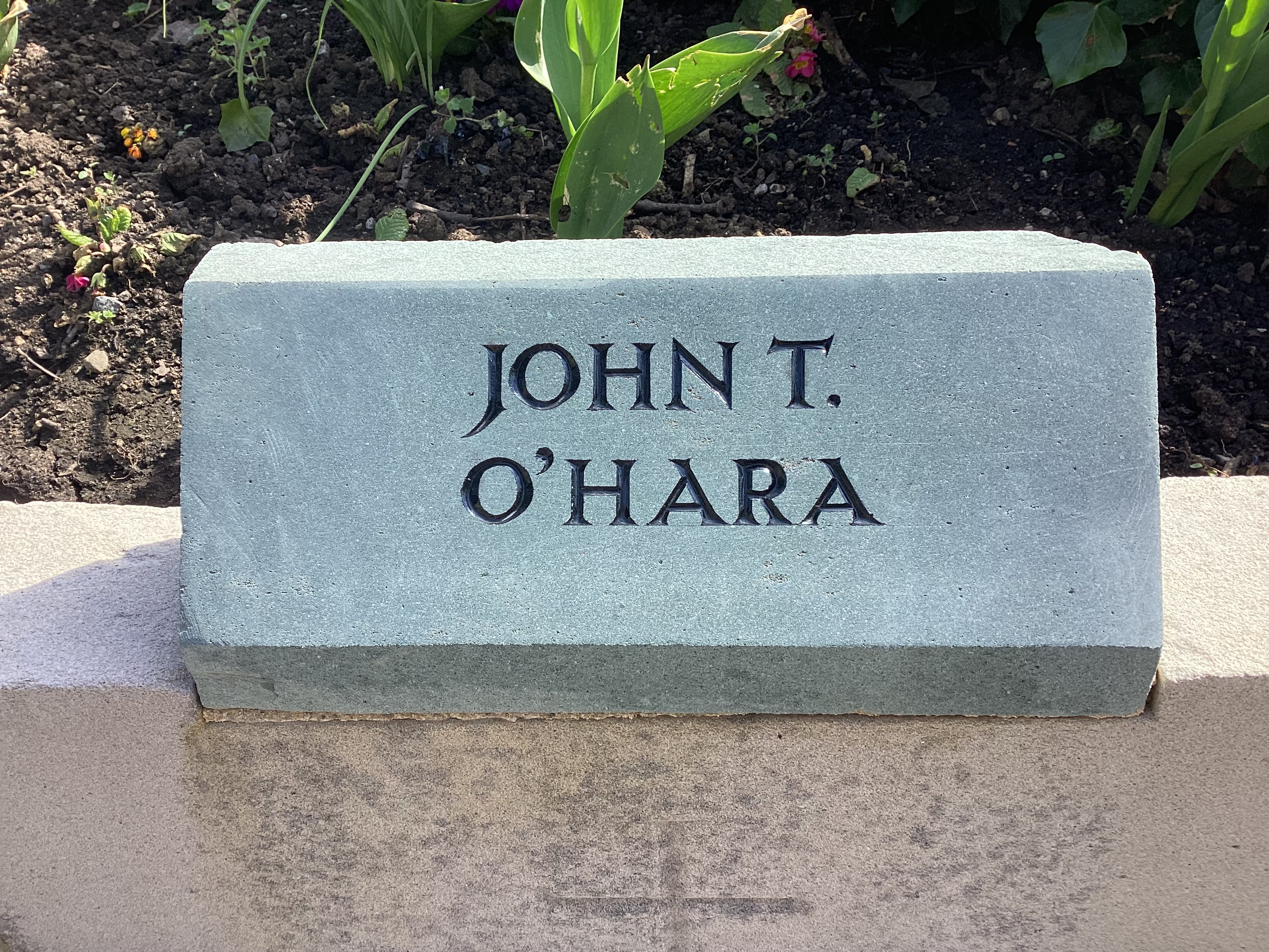 A green slate memorial stone with the name JOHN T. O'HARA engraved in black lettering.