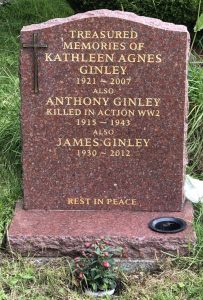 A pink granite headstone with a gently shaped top edge and gold painted lettering. This reads: Treasured memories of Kathleen Agnes Ginley 1921 - 2007. Also Anthony Ginley Killed in Action WW2 1915 - 1943 Also James Ginley 1930 - 2012 Rest in Peace