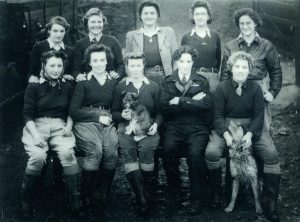A group photograph of ten Land Army girls in uniform. They worked at a chicken hatchery in Oakworth, West Yorkshire.