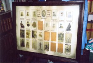 A framed and glazed war memorial with thirty photographs spaced apart in a special mount.