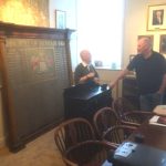 The memorial inside the boardroom at Wyedean Weaving. Two men are having a discussion.