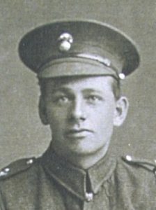 A head and shoulders portrait of a British Army soldier in uniform with a field service cap and the badge of the Northumberland Fusiliers.