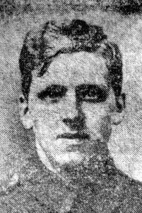 A poor quality photograph from a 1916 newspaper. It is of a man's head and shoulders and he is facing the camera.