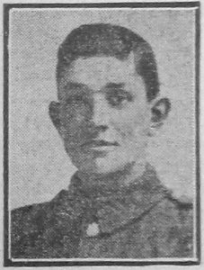 A rather poor quality photograph from a 1917 newspaper. It is of a man's head and shoulders and he is facing the camera.