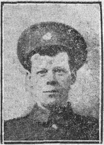A newspaper image of a man's head and shoulders. He is wearing Army uniform and a peaked cap with a badge.